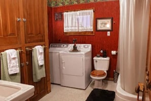 Washer and dryer unit in the bathroom. Stand up shower with tub.
