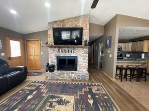 View from front window in living room to wood burning fireplace and hallway.
