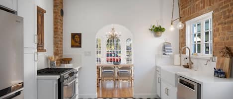 Modern kitchen with original hardware and exposed brick.  