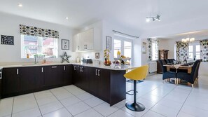 Spacious kitchen w/ modern appliances, open plan living room w/ comfortable seating & flat-screen TV. Ideal for socializing & entertaining. Cozy, comfortable & filled w/ natural light. Perfect for families & groups.