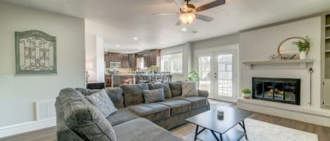 Open sunken living room area with fireplace and sectional.


