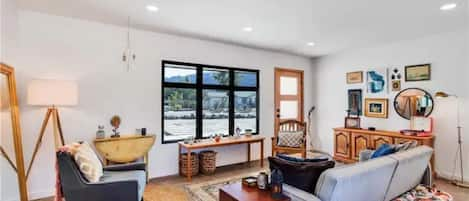 Livingroom with view of front door and wide window with view of mountains