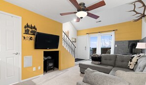 Unwind in the spacious living room, featuring a cozy sofa bed, flat-screen TV, and an inviting indoor fireplace.