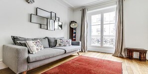 Bright and warm living room with grey sofa stylish lamp and dining for three