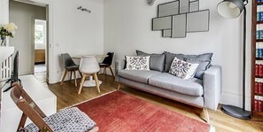 Bright and warm living room with grey sofa stylish lamp and dining for three