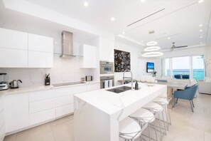 Fully stocked kitchen with gourmet appliances and island seating. 