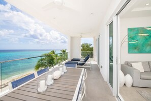 Balcony comes furnished with an alfresco dining table and a set of loungers. 