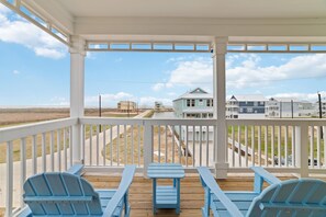 Relax on the primary balcony with panoramic ocean and beach views