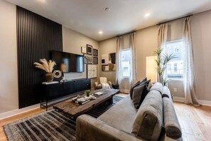 Second floor living area with large smart tv and comfy couch that lays flat as an extra sleeping space. The other sofa bed is in the game room. 