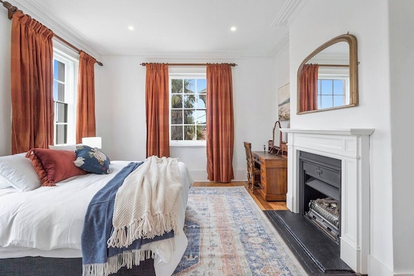 The generous primary bedroom comes with a plush king-sized bed, a decorative fireplace and a dedicated workspace.