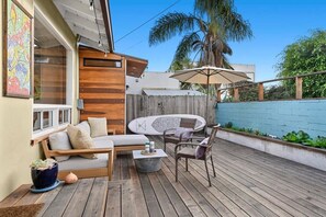 Spacious wooden plank back patio porhc with patio furniture