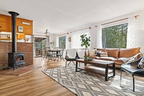 Relax in the inviting living room featuring a plush leather couch and cozy chairs, perfect for enjoying a movie night by the warm glow of the fireplace. A perfect space to unwind and create lasting memories