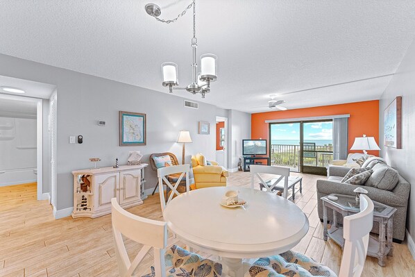 Bright dining and living area with a modern coastal design and natural lighting.