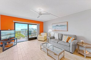Spacious living room with a sliding door leading to a balcony with ocean views.