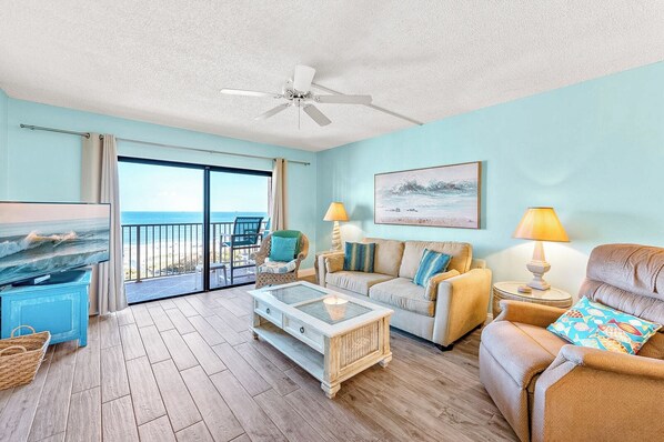 Relax in a cozy living room with stunning ocean views and warm sunlight.