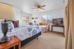 Master bedroom (upstairs) with California King bed, ceiling fan, ensuite bathroom, smart TV, private balcony