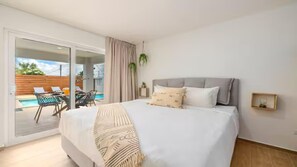 This bedroom is characterized by its natural and spacious feel. With air-condition, a native craft night stand, and indoor plants.