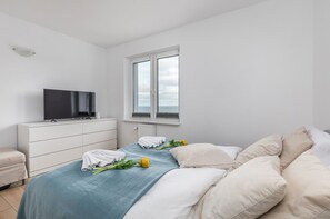 A spacious bedroom with a double bed, soft bedding, and a clean modern design.
