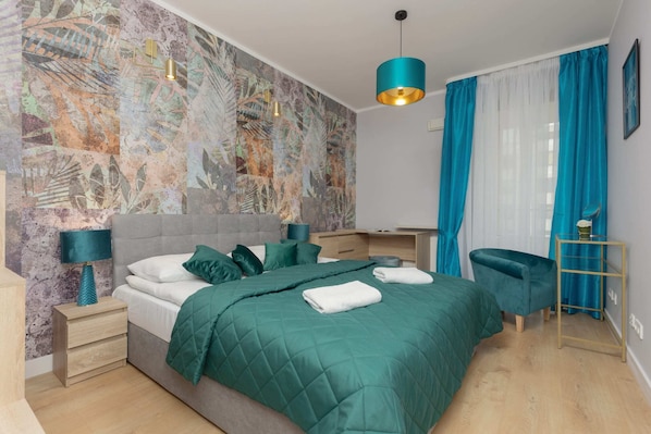 A modern bedroom with a vibrant green accent wall, teal curtains, and elegant bedding.
