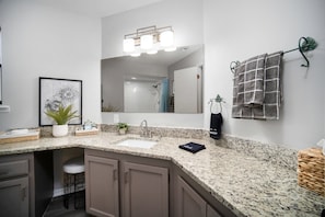 Start your day in this bright and modern bathroom, featuring elegant granite countertops and thoughtful touches of comfort.