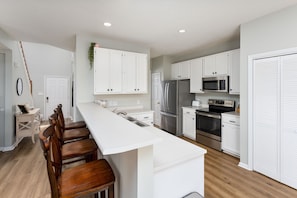 The kitchen is fully stocked with basic cooking supplies and utensils.