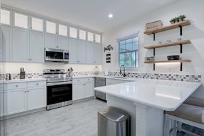 Our Kitchen Features Bright Lighting, Stainless Appliances and a Counter Height Barstools to have an Informal Meal