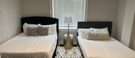 The comfortable bedroom includes 2 queen beds & ceiling fan