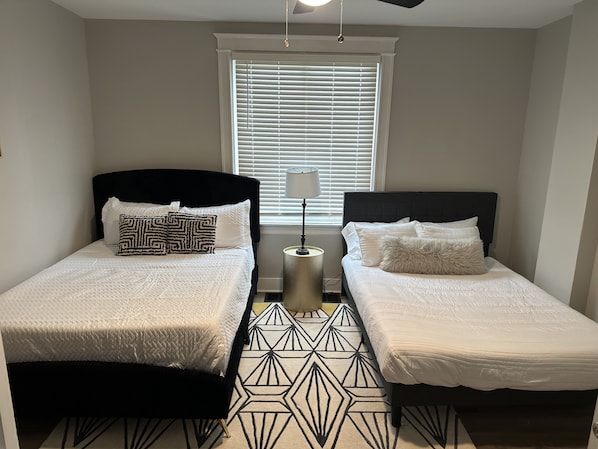 The comfortable bedroom includes 2 queen beds & ceiling fan