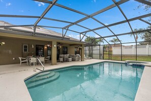 Covered patio and poolside area, ideal for outdoor dining or unwinding by the water.