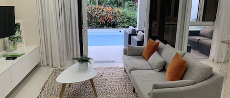 Living area with view of reflecting pool and landscaped, communal gardens.