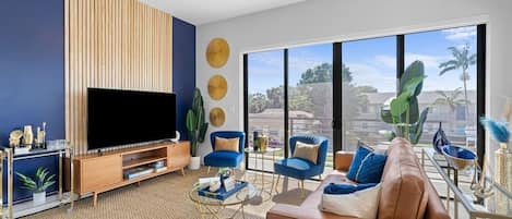 [Living Room] - wraparound balcony w/ views, genuine leather couch, velvet accent chairs, 65" TV w/ complimentary Netflix, board games, bar cart, blankets, custom accent wall