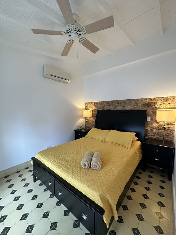 Main bedroom with comfortable bed, fans, AC, spacious closet and a bathroom. 