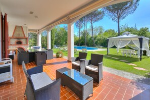 The equipped loggia open on the lawn close to the pool