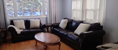 Living room area with couch, loveseat and an ottoman