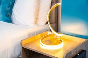 Bedside table with a lamp & disposable foam earplugs for a good night's sleep.