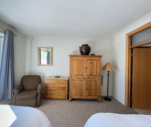 Imagine curling up with a good book in this inviting corner, complete with a plush armchair. The charming wooden furniture adds a rustic touch, making this space perfect for relaxation after a day of adventure. (Bedroom #1)