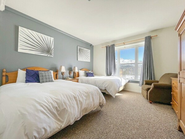 Wake up to the breathtaking mountain views from this cozy twin bedroom! The large windows fill the room with natural light, while the comfortable beds promise restful nights. You'll love the serene ambiance and stylish decor. (Bedroom #1 with 2 full size beds)