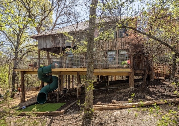 Your treehouse is in the middle of a forest and 15 feet off the ground! Check out that spiral slide!
