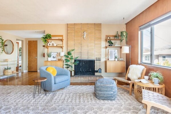 Spacious living room with mid century fireplace overlooking the mountains. 