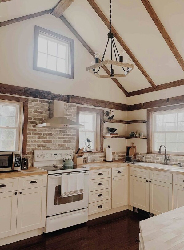 Our sun-filled kitchen stocked with basic cooking supplies. Original wood beams.