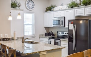 Fully equipped kitchen with stainless steel appliances and beautiful counter tops