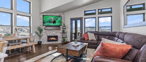 Cozy space with a fireplace, sofa set, and views from windows.