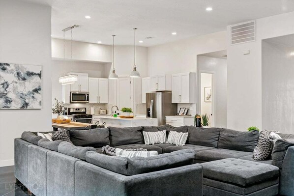 This inviting living room features a huge sectional perfect for relaxing after a day of adventure. Enjoy movie nights on the flat-screen TV or cozy up by the fireplace, creating the perfect atmosphere for unwinding with family and friends.
