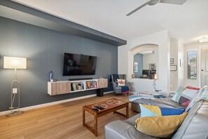 Living room w/ 65" TV and Roku streaming box. 