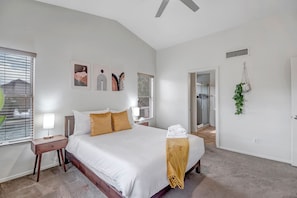 Main bedroom with hanging plant and attached bathroom.