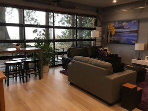 View of living room, showing garage doors and outdoor patio area.