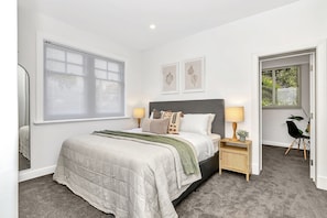 Regal comfort in Bedroom 1, king bed. Note walk-through to Bedroom 2.