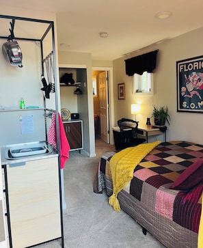 First room with a queen bed and kitchenette on the other side.