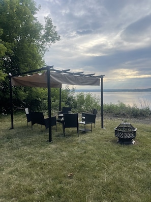 Newly added pergola with seating and a fire pit to enjoy the Manistee Lake view!
