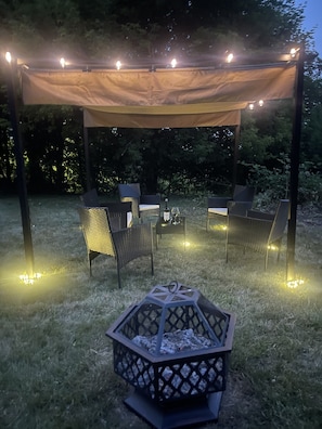 Newly added pergola with seating and a fire pit to enjoy the Manistee Lake view!